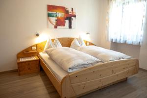 a bed with two pillows on it in a room at Garni Meinrad in Auer