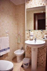uma casa de banho com um lavatório, um WC e um espelho. em HOTEL LORENZO em Carvalhinho