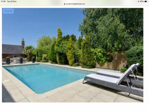 a swimming pool with a bench next to at Sparkenhoe House in Nuneaton