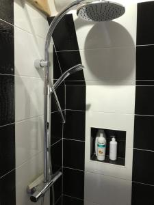 eine Dusche im Bad mit schwarzen und weißen Fliesen in der Unterkunft villa santa lucia in Pornic