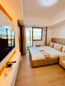 a bedroom with a large bed and a flat screen tv at Elitista Chateau Azure North Pampanga in San Fernando
