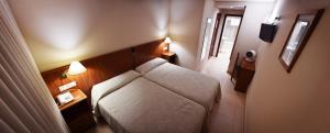 uma sala de estar com um sofá num quarto em HOTEL LORENZO em Carvalhinho