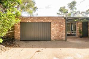 een bakstenen gebouw met een grote garage bij Coastal cottage, perfectly positioned in Tootgarook