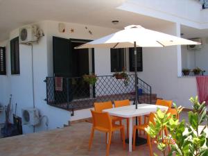 einen Tisch und Stühle mit Sonnenschirm auf einer Terrasse in der Unterkunft Casa Albertina in Castro di Lecce