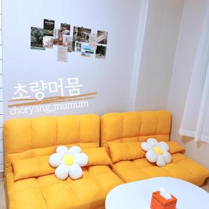 un soggiorno con divano giallo e fiori di choryang mumum 201 a Busan