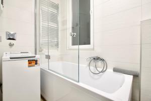 een badkamer met een bad en een glazen douche bij Premium Apartment by Hi5- Near New York Cafe in Boedapest