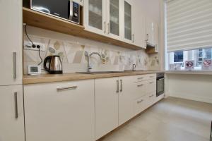 een keuken met witte kasten en een wastafel bij Premium Apartment by Hi5- Near New York Cafe in Boedapest