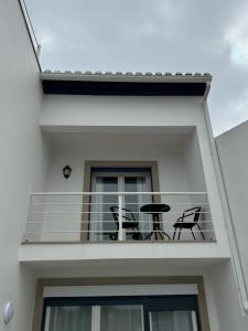 einen Balkon mit zwei Stühlen und einem Tisch darauf in der Unterkunft Sunny baleal guesthouse in Ferrel