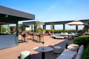 eine Terrasse mit Sofas, Tischen und Stühlen in der Unterkunft The Westin Palace, Milan in Mailand