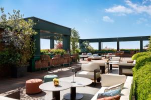 eine Terrasse mit Tischen, Sofas und Stühlen in der Unterkunft The Westin Palace, Milan in Mailand