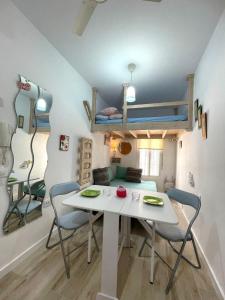 a room with a table and chairs and a bunk bed at PRECIOSO Y PEQUEÑO LOFT CENTRO DE CONIL in Conil de la Frontera