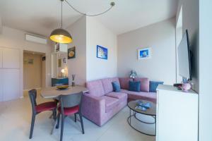 萊里奇的住宿－B&B Lerici Al Mare，客厅配有粉红色的沙发和桌子