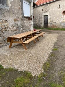 - une table de pique-nique en bois installée devant un bâtiment dans l'établissement Gîte o prés de la Loire, à Ousson-sur-Loire