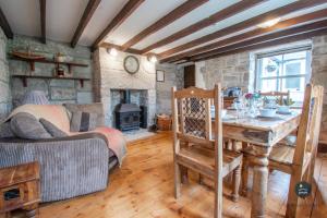 a living room with a table and a fireplace at Dolphin Cottage Chesil Beach in Portland