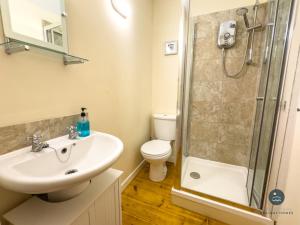 a bathroom with a sink and a toilet and a shower at Dolphin Cottage Chesil Beach in Portland +13 photos