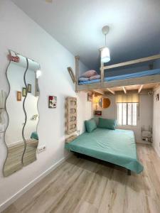 een kamer met een groen bed in een kamer bij PRECIOSO Y PEQUEÑO LOFT CENTRO DE CONIL in Conil de la Frontera