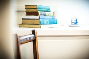 una pila de libros sentados en un escritorio con una silla en Sparkenhoe House en Nuneaton