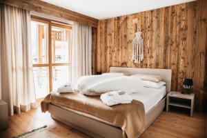 a bedroom with a bed with towels on it at Exzelent Residence in Anterselva di Mezzo