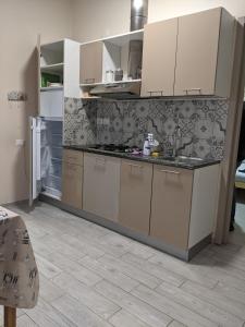a kitchen with white cabinets and a tile floor at lake dreams in Verbania