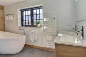 uma casa de banho branca com uma banheira e um lavatório em Chalet de standing avec sauna em Saint-Jean-dʼAulps