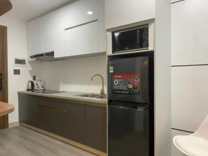 een keuken met een zwarte koelkast en een magnetron bij Căn hộ studio chung cư cao cấp Sophia Center in Ấp Rạch Mẹo