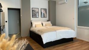 Schlafzimmer mit einem Bett mit weißer Bettwäsche und Kissen in der Unterkunft Gallery Apartment in Bonn