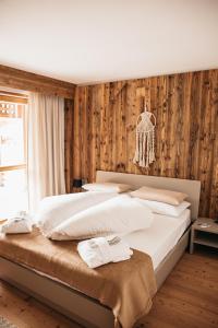 a bedroom with two beds with white sheets at Exzelent Residence in Anterselva di Mezzo