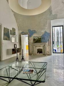 ein Wohnzimmer mit einem Glastisch und einem Kamin in der Unterkunft Capri Kronos GuestHouse in Anacapri