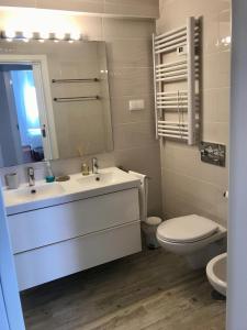 a bathroom with a sink and a toilet and a mirror at Algarve dream seaview apartment w/pool near beach in Porches