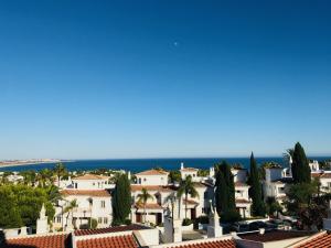 a view of a town with palm trees and houses at Algarve dream seaview apartment w/pool near beach in Porches
