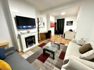 a living room with a couch and a fireplace at 4 Bedrooms, 2 Bathrooms, Parking, Spacious House in London