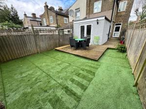 a backyard with a table and chairs and a fence at 4 Bedrooms, 2 Bathrooms, Parking, Spacious House in London