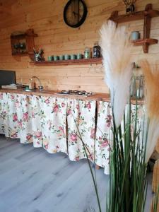 eine Küche mit einer Theke und einem Tisch mit Blumen in der Unterkunft Chatka na Wzgórzu, Staw z możliwością łowienia ryb, Cisza, Spokój in Barczewo