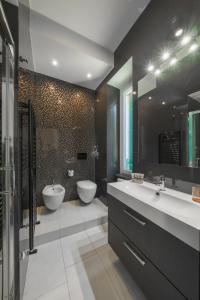 uma casa de banho com 2 lavatórios, um WC e um chuveiro em B&B Lerici Al Mare em Lerici