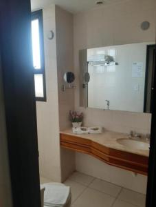 a bathroom with a sink and a mirror at Flat Bassano Vaccarini in Ribeirão Preto