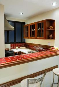 a kitchen with wooden cabinets and a counter top at Flat Bassano Vaccarini in Ribeirão Preto
