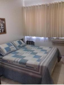 a bedroom with a blue and white checkered bed at Flat Bassano Vaccarini in Ribeirão Preto