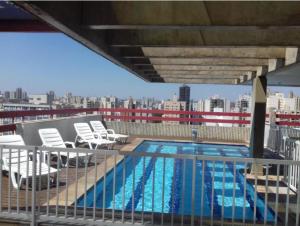 a swimming pool on the roof of a building at Flat Bassano Vaccarini in Ribeirão Preto