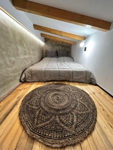 ein Schlafzimmer mit einem Bett und einem Teppich auf einem Holzboden in der Unterkunft Ktimaoliva2 in Nafpaktos