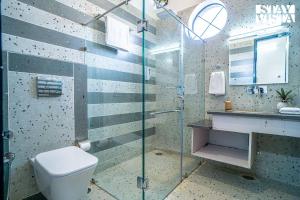 Un baño con inodoro y ducha de cristal. en StayVista at Ivycrest Estate, en Dehradun 17 fotos más