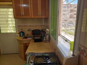una pequeña cocina con fregadero y ventana en Hi Home, en Meknès