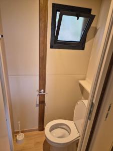 a small bathroom with a toilet with a window at Chalet maisonette dans hameau calme in Bonifacio