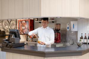 a man standing in a kitchen preparing food at Hotel Santa Faz in Benidorm