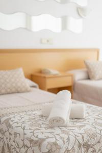 Dos toallas en una cama en una habitación de hotel en Hotel Santa Faz, en Benidorm