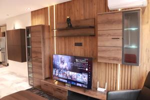 sala de estar con TV en una pared de madera en LUXE APPARTEMENT, en Casablanca