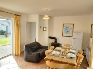 a living room with a table and a leather chair at No3 Ballyconneely Cottage in Ballyconneely +20 photos