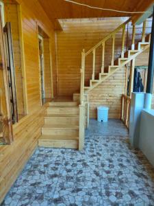 una escalera de madera en una habitación con suelo de madera en waterfall, en Mestia
