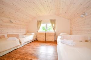 a room with two beds and a window at Dębowa Osada in Bobolin