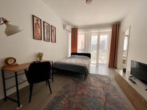 Dormitorio con cama, escritorio y TV en BELVEDERE Apartments, en Bucarest