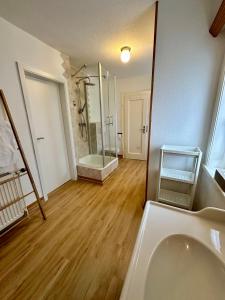 La salle de bains est pourvue d'une douche et d'une baignoire. dans l'établissement Haus Schneekappe (Winterberg), à Winterberg